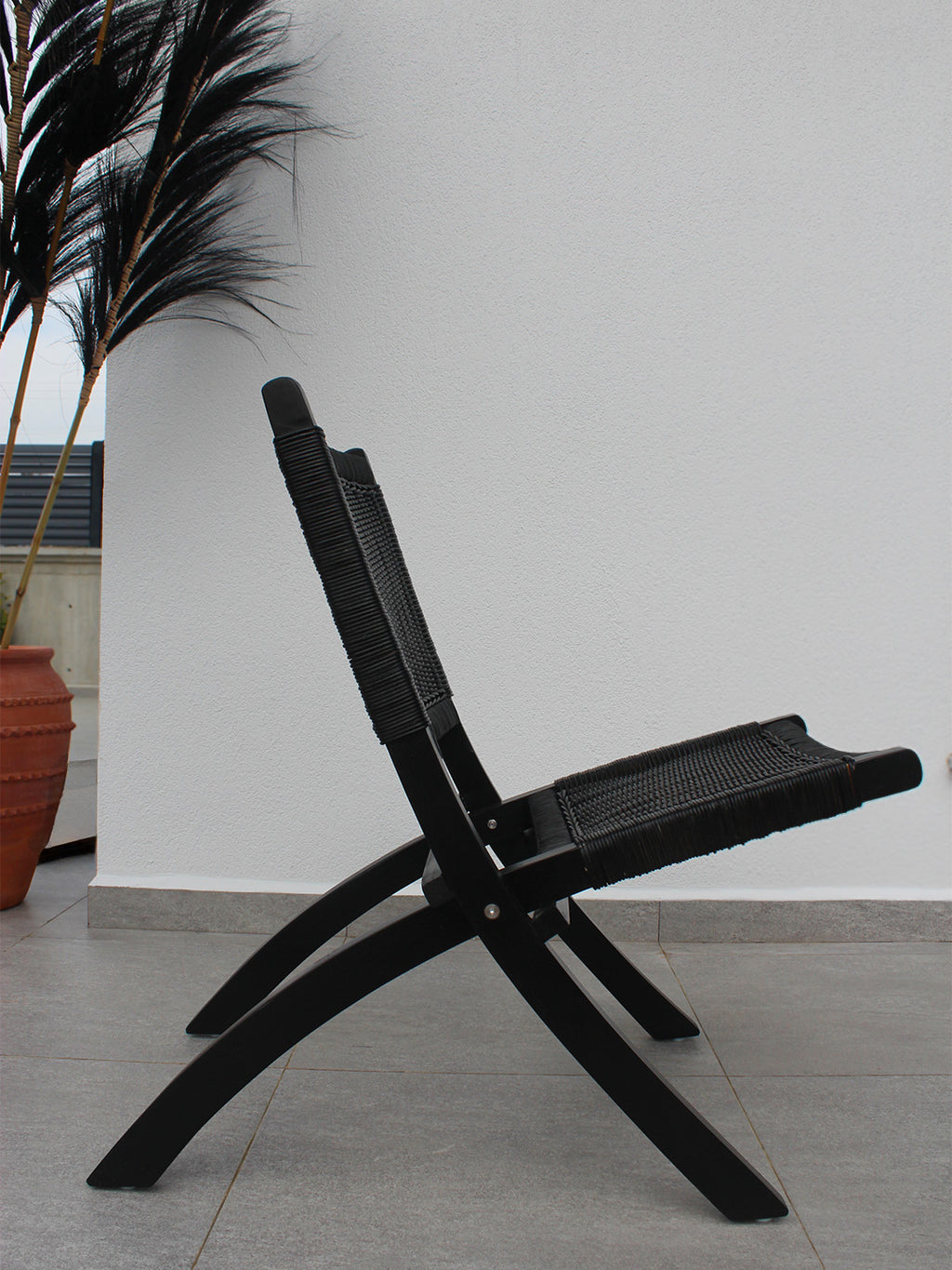 AYOMI markalı, siyah Bali katlanır tik sandalye. Masif tik (teak) ve ince rattan örme. Dayanıklı outdoor sandalye.