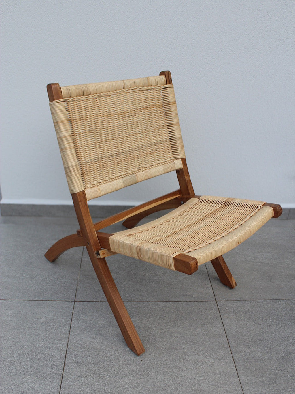 AYOMI Bali katlanır sandalye, doğal tik ağacı iskelet ve el örgüsü rattan oturma yüzeyi ile şık bahçe mobilyası.