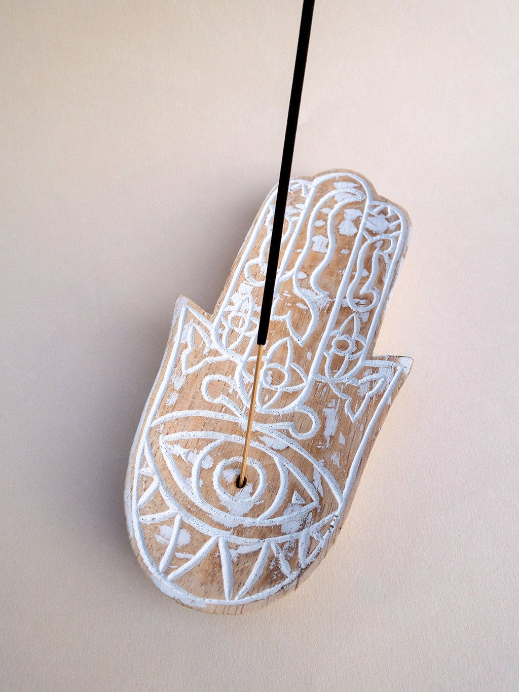 19 cm ahşap Hamsa tütsülüğün göz motifindeki deliğe yerleştirilmiş tütsü çubuğu yakından görülmektedir