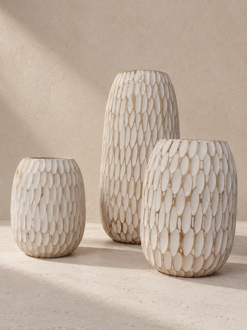 AYOMI GILI set of three white hand-carved balsa wood vases with organic teardrop shapes and rustic whitewash finish.