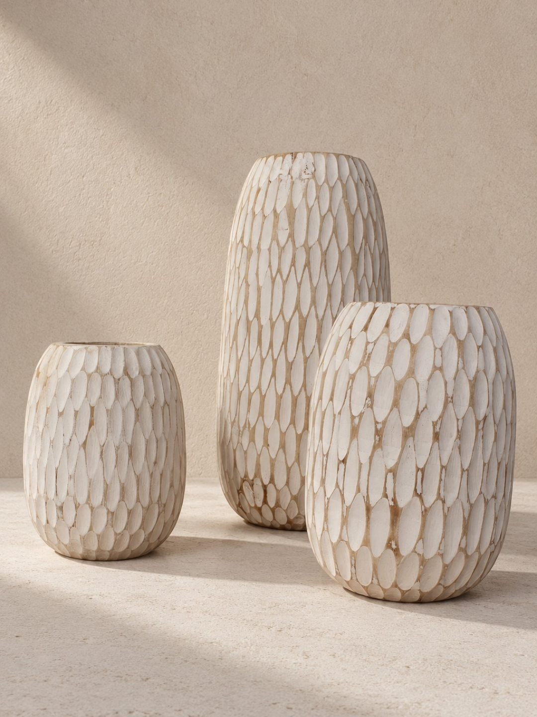 AYOMI GILI set of three white hand-carved balsa wood vases with organic teardrop shapes and rustic whitewash finish.