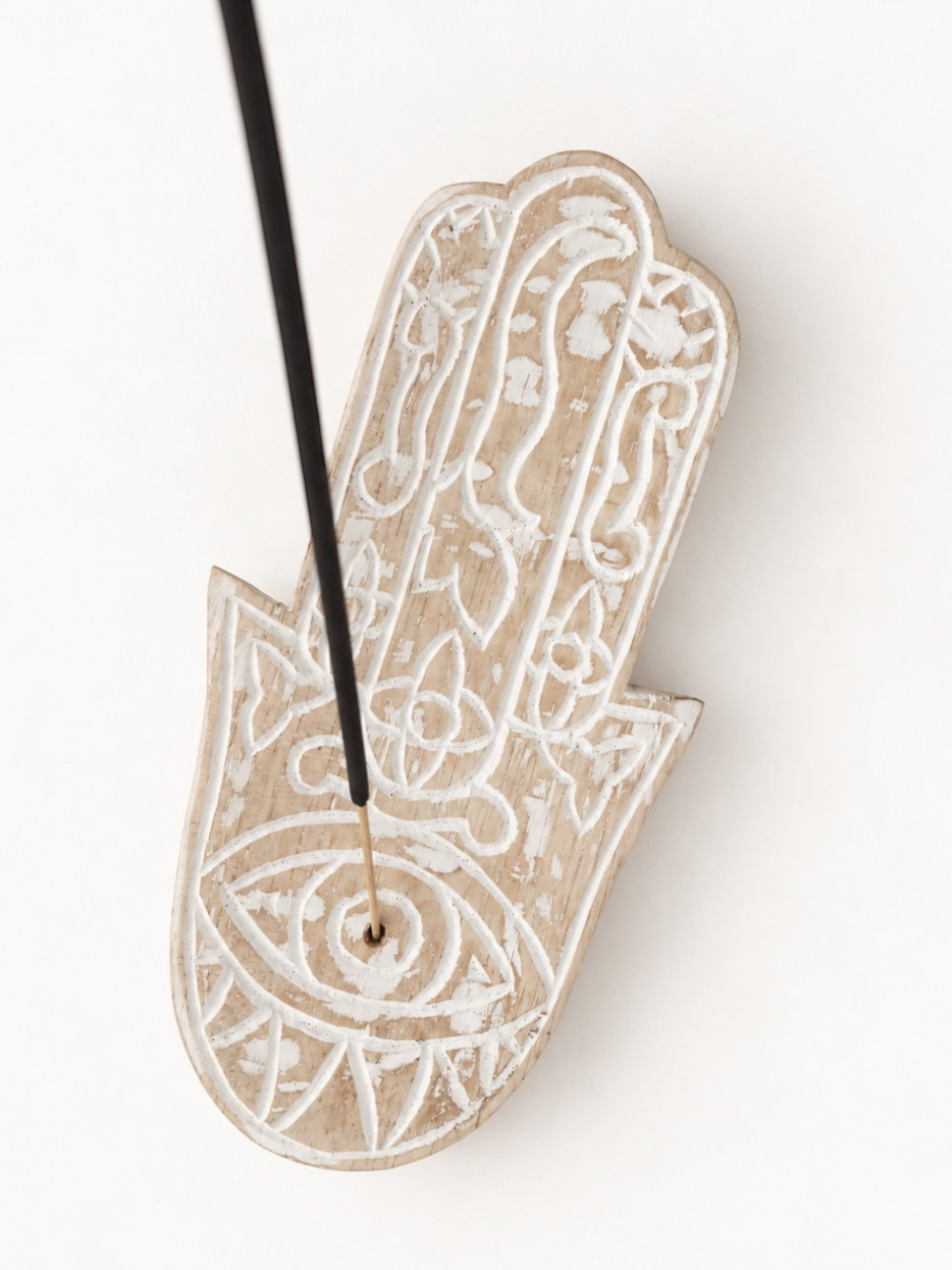 AYOMI hand-carved balsa wood Hamsa incense holder with eye detail and a burning incense stick