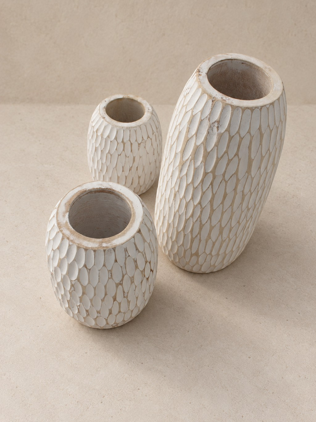 AYOMI set of three white whitewashed balsa wood vases with hand-carved organic textures for dry floral arrangements.